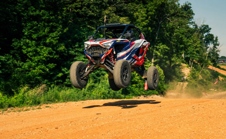 Airborne UTV with red white and blue high-tack printable vinyl graphics on an off-road track