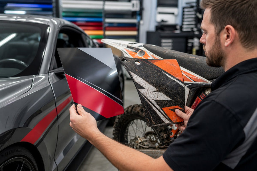 Technician comparing smooth vehicle graphics and rugged dirt bike applications